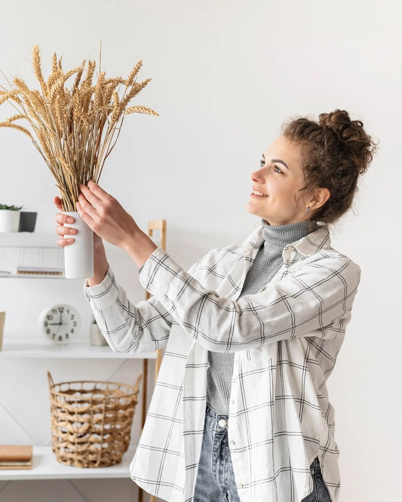 Halbnahe Aufnahme einer lächelnden Frau, die Pflanzen hält.