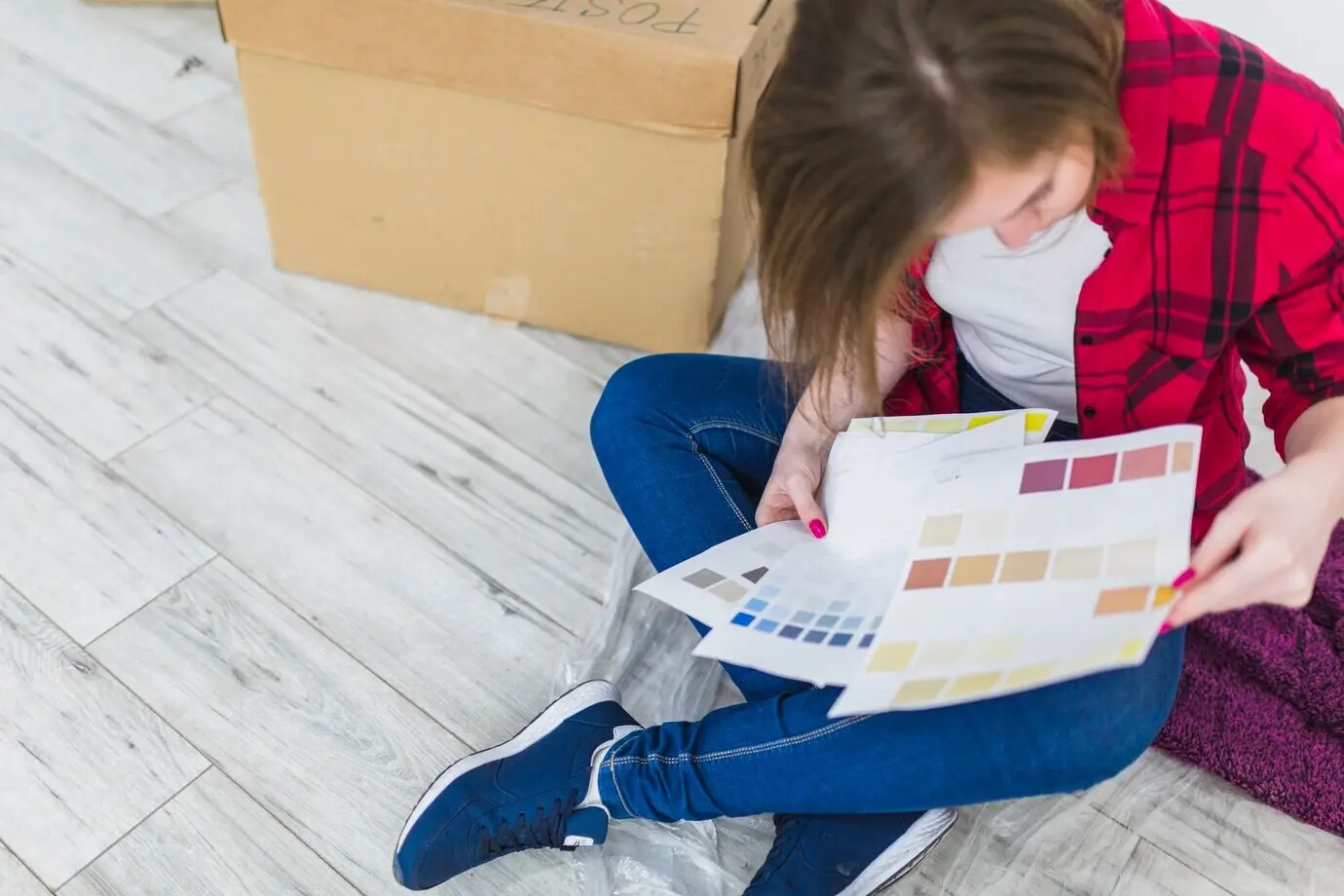 Von oben: Frau blickt auf Farbmuster.